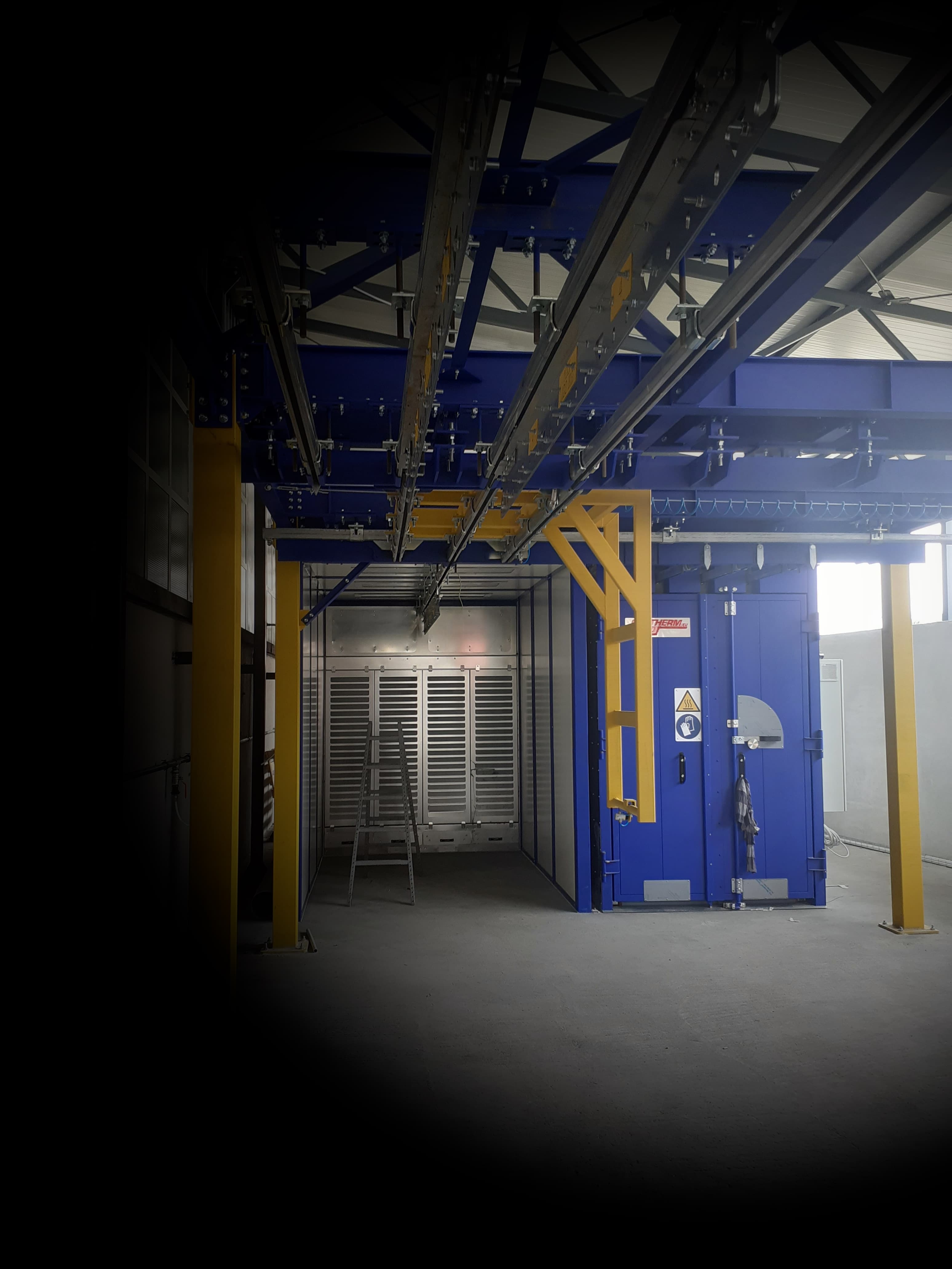 Transportni sustav i kabina za praškasto lakiranje u industrijskom okruženju, dio proizvodnog procesa bez prisutnosti ljudi